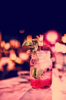 Close up of red cocktail in glass jar at counter in bar