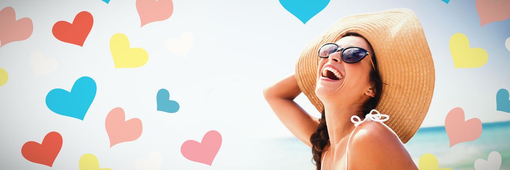 Illustrative image of colorful heart shapes against  portrait of smiling woman on the beach Portrait of smiling woman on the beach on a sunny day