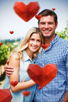 Red heart with white blackground against portrait of happy couple embracing at vineyard