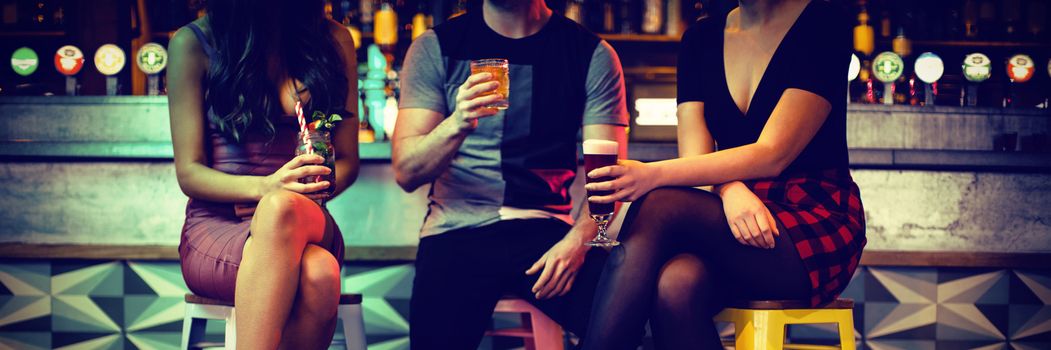 Friends enjoying the drinks at counter in bar