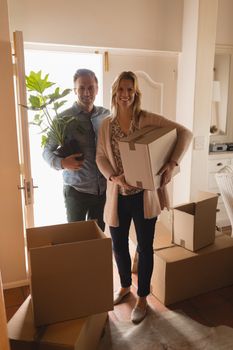 Portrait of attractive happy couple wearing casual clothes moving into new home