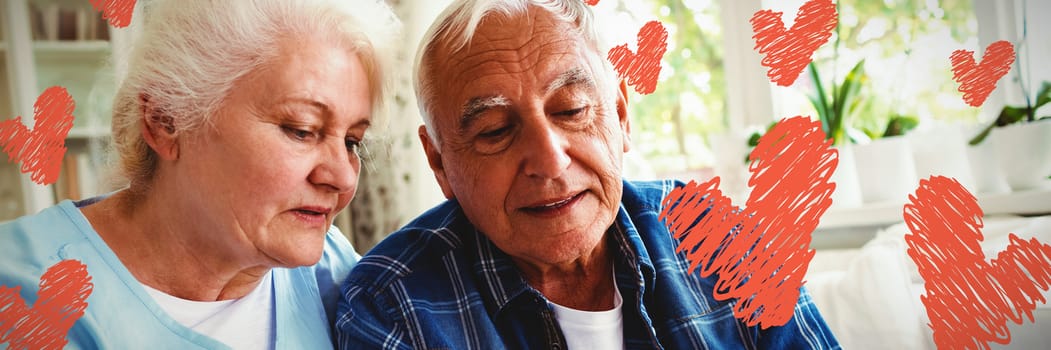 Red Hearts against senior couple using mobile phone