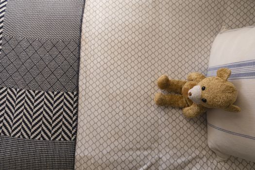 Overhead view of teddy bear on a bed in bedroom at home