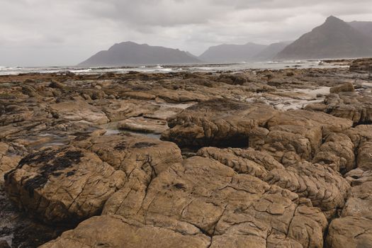 Wide view of rocky beach with beautiful mountains