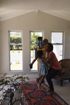 Front view of a multi-generation African American family having fun in living room at home