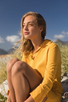 Side view of young woman relaxing on the beach on a sunny day