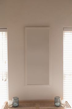 Modern wall frame fixed on the wall between two lamps at home