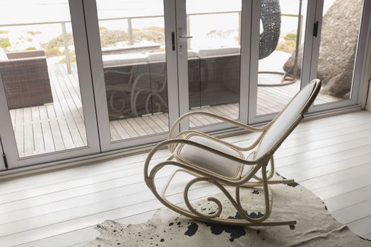 High angle view of an empty modern rocking chair placed near the window at home