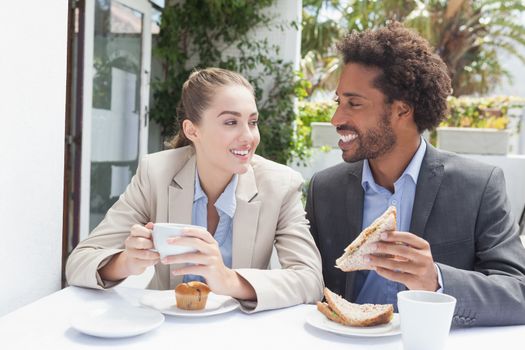 Happy business people on their lunch outside at the coffee shop