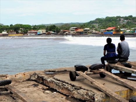 Livingstone harbour quay side dock with two lovers looking at the beach and sea