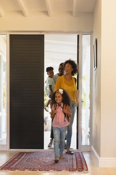 Front view of happy African American family returning sweet home