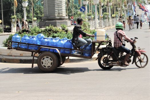Water delivery in cambodia asia. drinking water delivered by moto bike and trailer