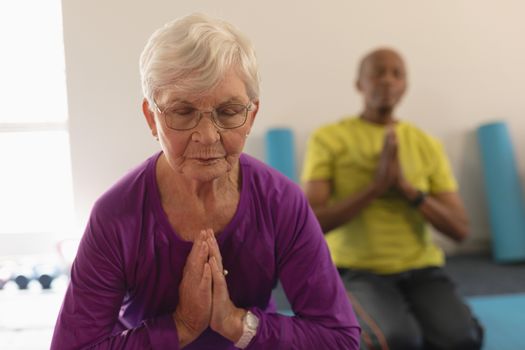 Front view of senior woman doing yoga in fitness studio