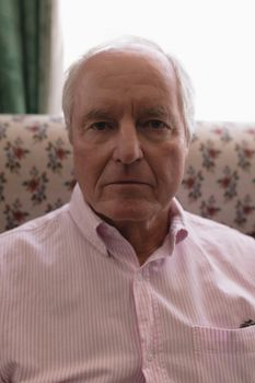 Close up of active senior man relaxing in living room sitting on the sofa at home