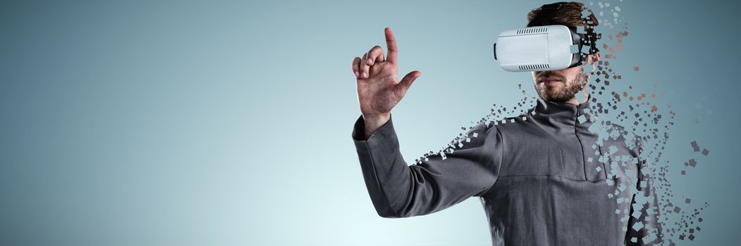 Man gesturing while using virtual reality headset against abstract grey background