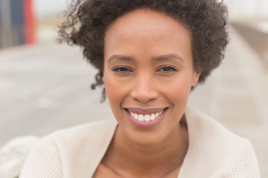 Portrait of happy young African American woman looking at camera. She is smiling