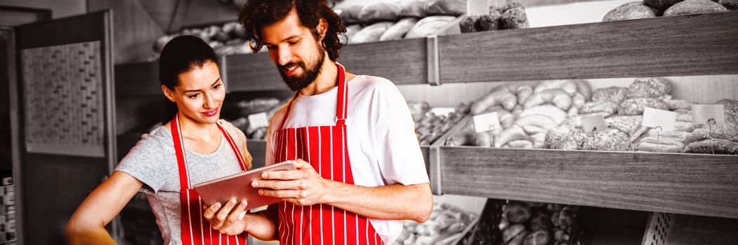 Couple using digital tablet in bakery shop