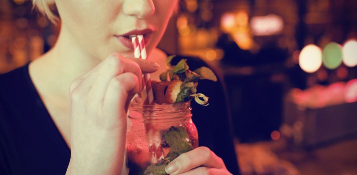 Portrait of beautiful woman having cocktail in bar