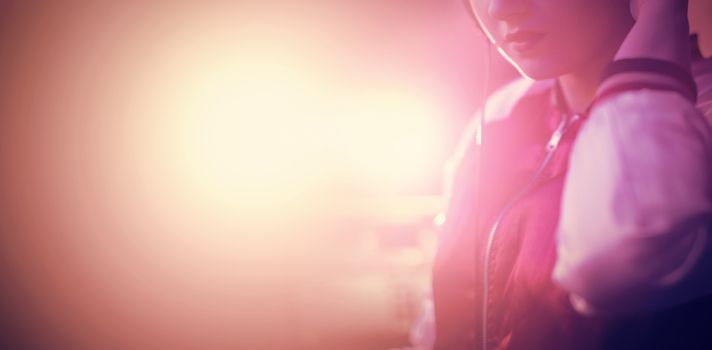 Portrait of female dj listening to music in headphones at bar