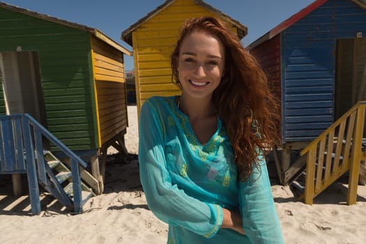 Portrait of happy gorgeous young Caucasian woman looking at camera standing on the beach. She is smiling and enjoying at camera