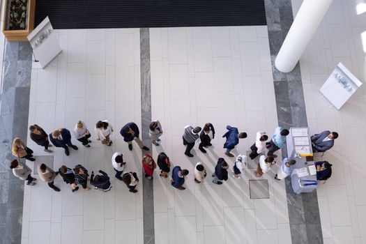 High angle view of multi-ethnic group business people standing in queue at office