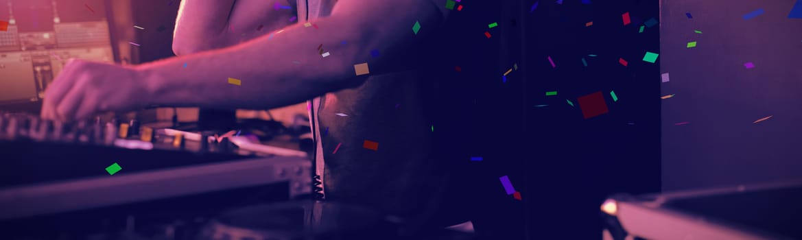 Flying colours against male dj listening to headphones while playing music
