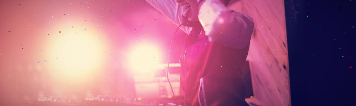 Flying colours against female dj having fun while playing music in bar