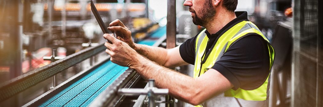 Attentive factory worker using a digital tablet in factory