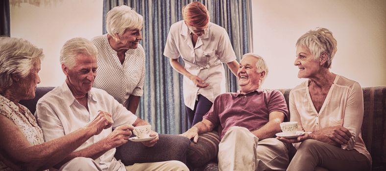 Seniors interacting with nurse in the retirement house