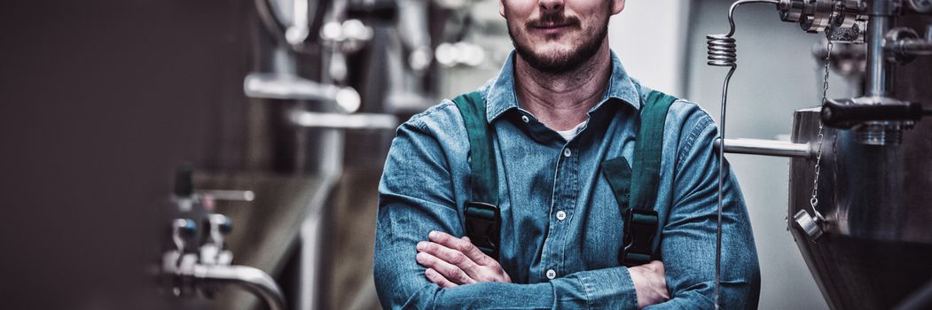 Portrait of confident maintained worker standing with arms crossed at brewery