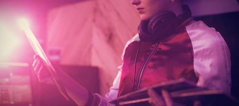 Beautiful female dj holding a vinyl disc record in bar