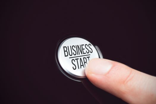 Business start in capital letter against finger pressing a button