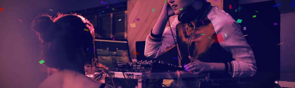 Flying colours against female dj playing music while interacting with woman