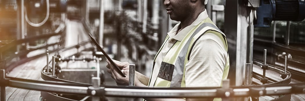 Factory worker using a digital tablet near the production line in factory