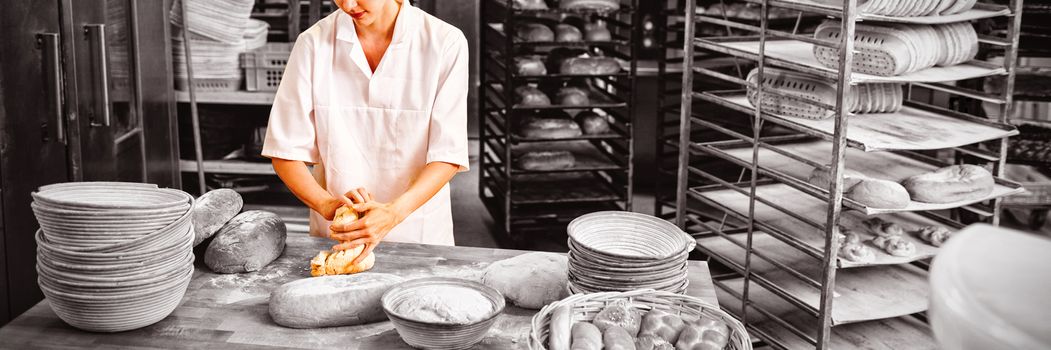 Female baker kneading a dough in bakery shop