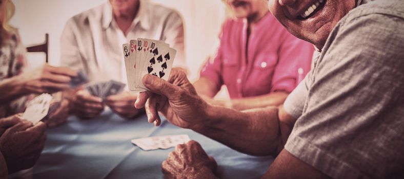 Group of seniors playing cards in the retirement house