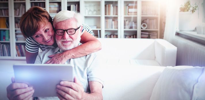 Senior couple using digital tablet in living room