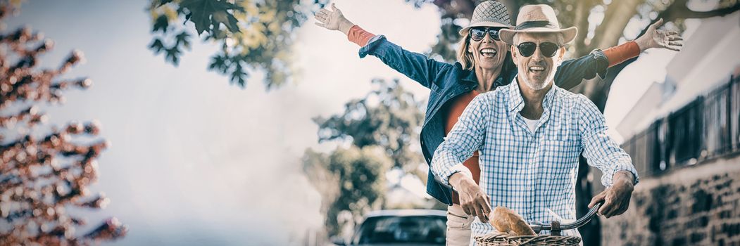 Mature couple enjoying while riding bicycle in city