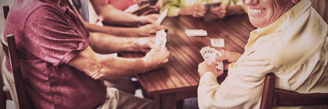 Seniors playing cards together in a retirement home