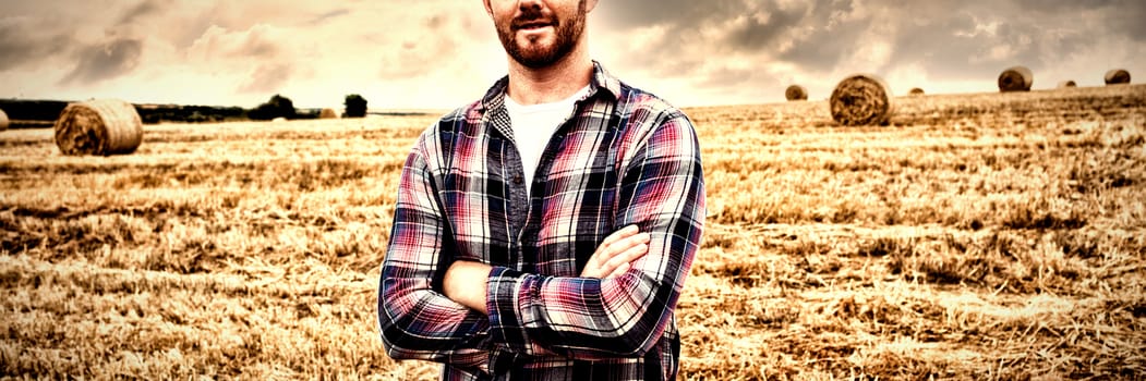 Portrait of farmer standing with arms crossed in the field on a sunny day