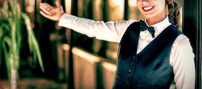 Portrait of smiling waitress welcoming in restaurant