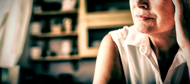 Worried senior woman with hand on forehead at home