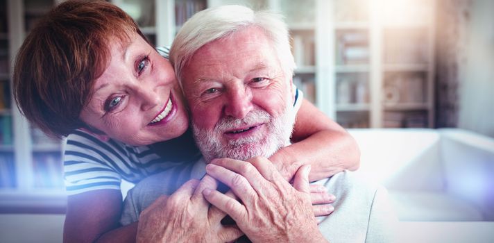 Portrait of senior woman embracing man in living room