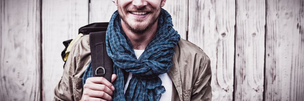 Happy young man carrying backpack outdoors