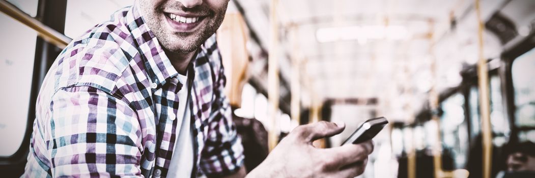 Portrait of handsome man using mobile phone in bus