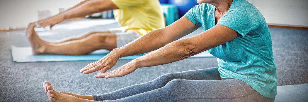 Seniors stretching legs in studio