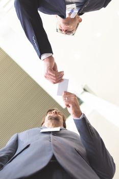 Upward view of diverse business people exchanging business card in conference