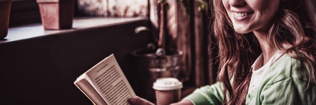 Attractive girl posing with book at coffee shop