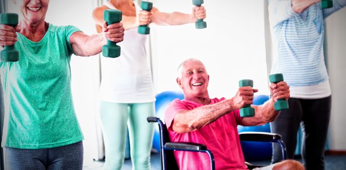 Portrait of seniors exercising with weights during sports class
