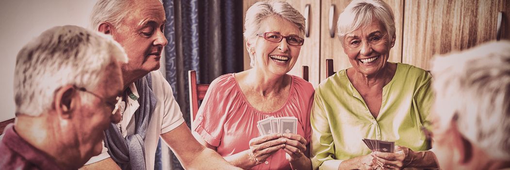 Seniors playing cards together in a retirement home